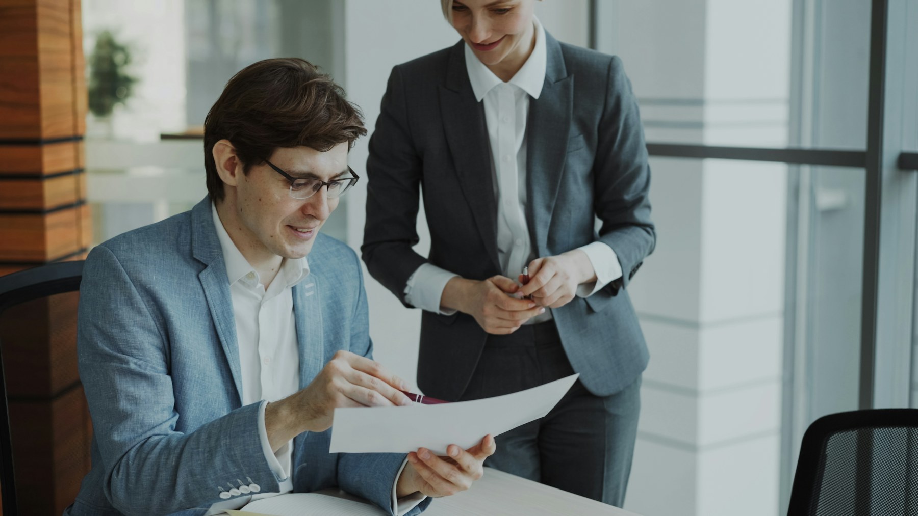 Two professionals reviewing a document together at a conference table